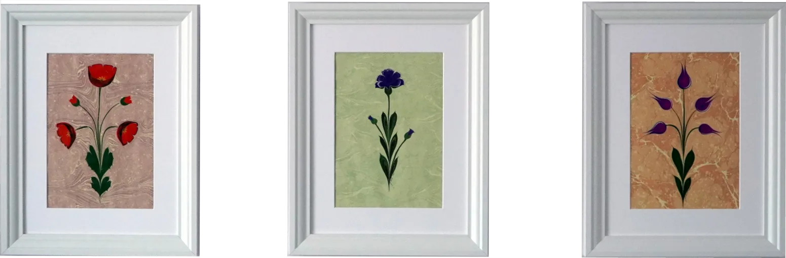Three Ebru Blooms — three white-framed ebru flowers: red poppies on rose, a blue carnation on green, and purple tulips on peach